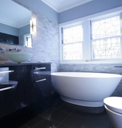 Sydney Bathroom Renovators - black bathroom with black sink cabinet and round white bathtub