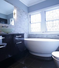 Sydney Bathroom Renovators - black bathroom with black sink cabinet and round white bathtub