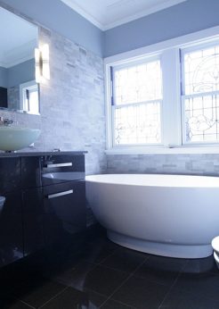 Sydney Bathroom Renovators - black bathroom with black sink cabinet and round white bathtub