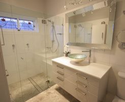 Sydney Bathroom Renovators - Small bathroom with white shower and white cabinets