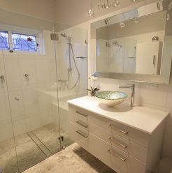 Sydney Bathroom Renovators - Small bathroom with white shower and white cabinets