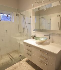 Sydney Bathroom Renovators - Small bathroom with white shower and white cabinets