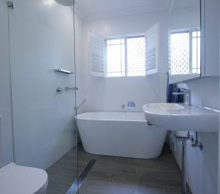 Sydney Bathroom Renovators - Small white bathroom with bathtub at the end