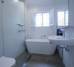 Sydney Bathroom Renovators - Small white bathroom with bathtub at the end